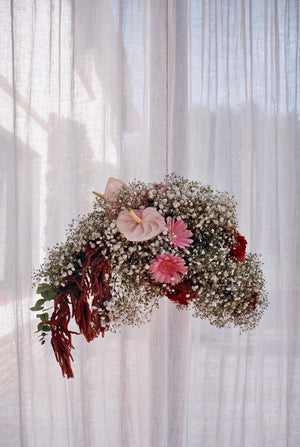 Hanging flower arrangement with pink, white, burnt red flowers in the shape of a cloud. Photography 0K Studios