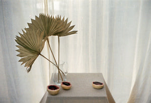 Table with pampas grass in a clear glass vase and slow roasted salt baked beetroot on a table. Photography 0K Studios.