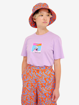 Model wearing Crimson Rose Es Vedrà lilac T-shirt with orange floral print shorts and bucket hat. Photography Rowan Corr.